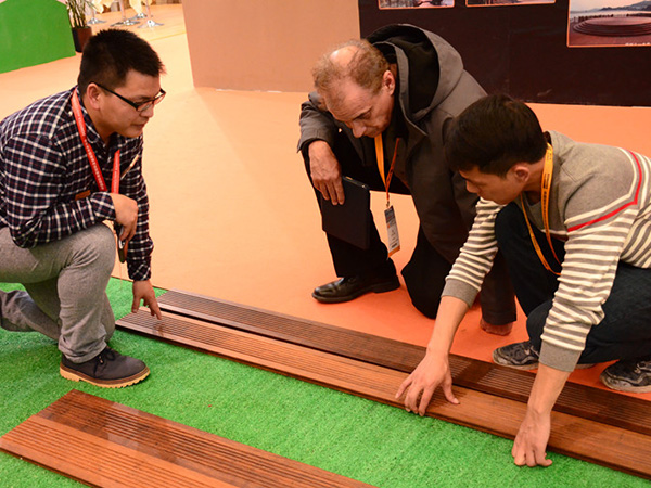 International client inspecting outdoor bamboo decking quality on site